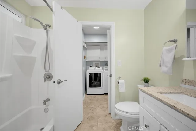 a bathroom with a granite countertop toilet a sink and bathtub