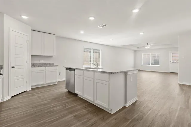 a view of a kitchen with wooden floor and electronic appliances