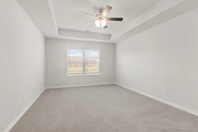 an empty room with a window and a ceiling fan