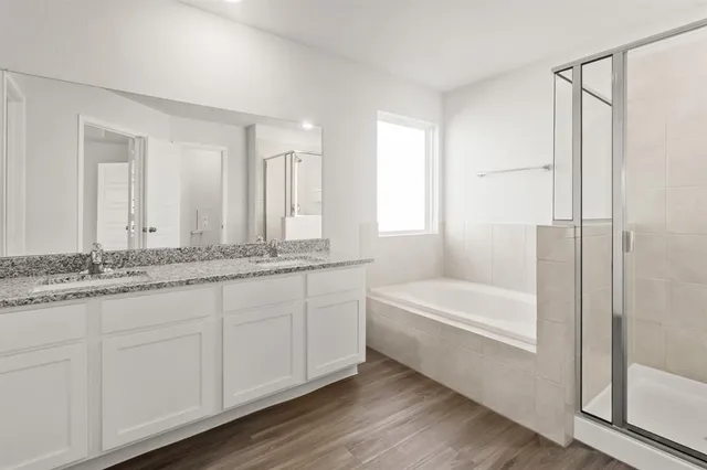 a bathroom with a granite countertop sink and a bathtub