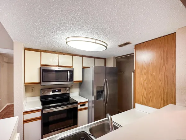 a kitchen with stainless steel appliances a refrigerator and a stove top oven