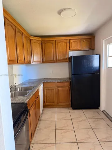 a kitchen with a refrigerator and a sink