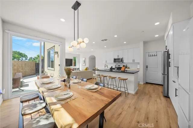 a view of a dining room and livingroom with furniture wooden floor a chandelier
