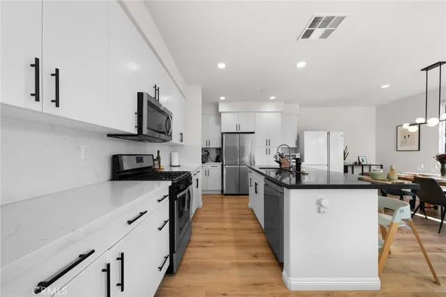 a kitchen with stainless steel appliances a sink counter space cabinets and a center island