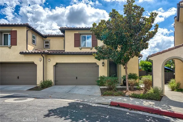 a view of a white house with large windows and a small yard