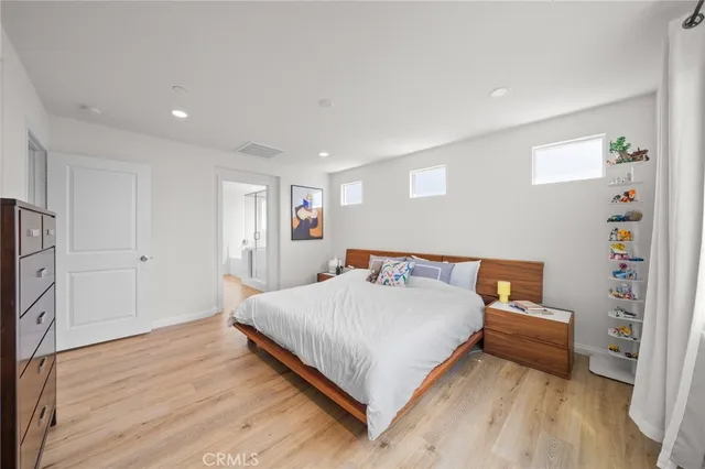 a bedroom with a bed and a wooden floor