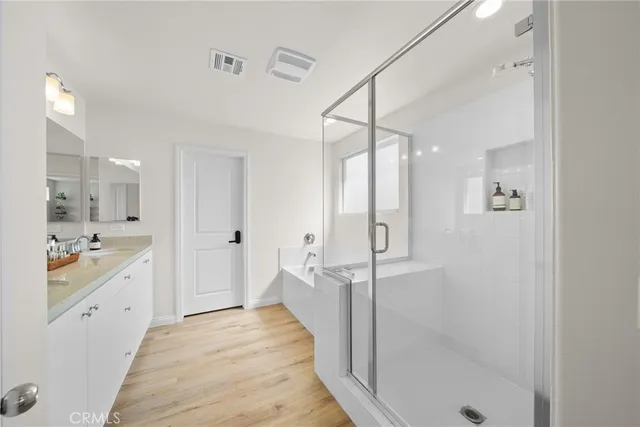 a bathroom with a glass shower door a sink and a bathtub