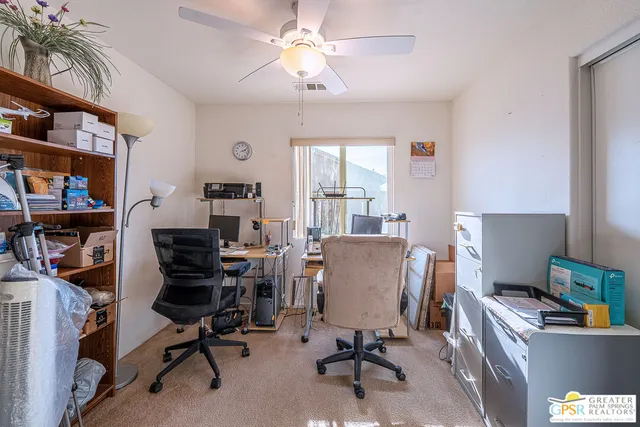 a view of a workspace with furniture and a window