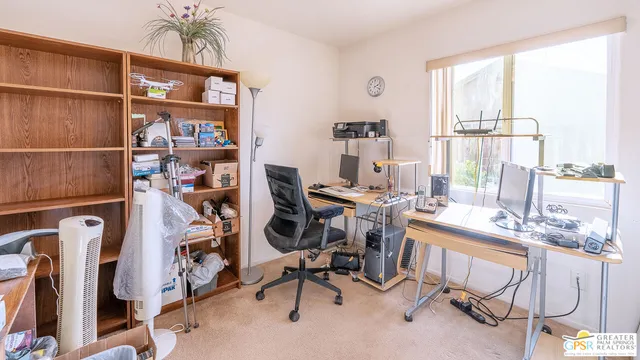 a view of a workspace with furniture and a window