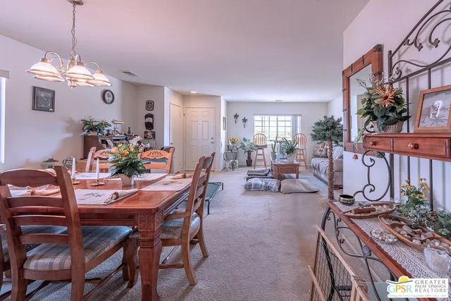 a view of a dining room with furniture a chandelier and wooden floor