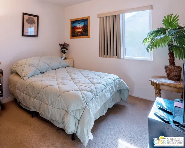 a bed sitting in a bedroom next to a window