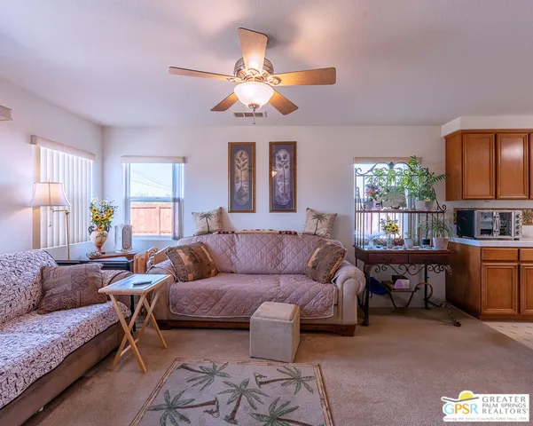 a living room with furniture a chandelier and a window