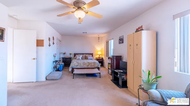 a bedroom with furniture and a chandelier fan