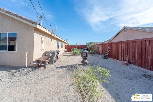 a backyard of a house with table and chairs