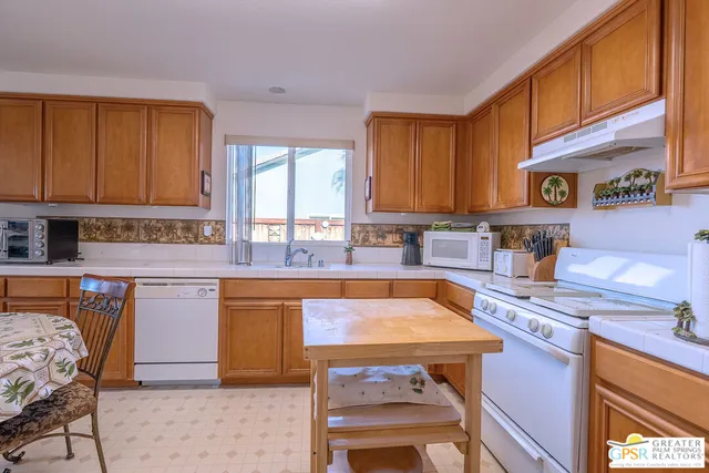 a kitchen with stainless steel appliances granite countertop a stove a sink dishwasher and cabinets with wooden floor