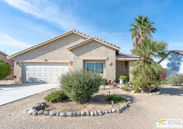 a front view of a house with a yard and outdoor seating