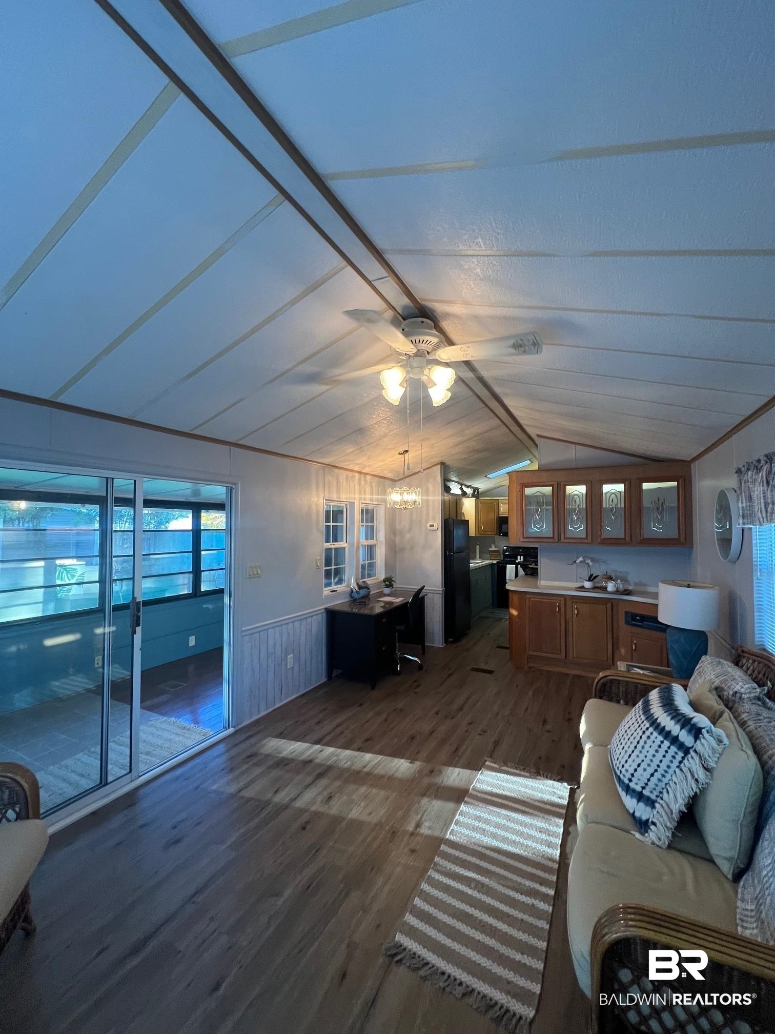 698 Escambia Loop Lillian, AL 36549 - Photo 5 of 16 Living room featuring wooden walls, lofted ceiling, ceiling fan, and dark hardwood / wood-style flooring
