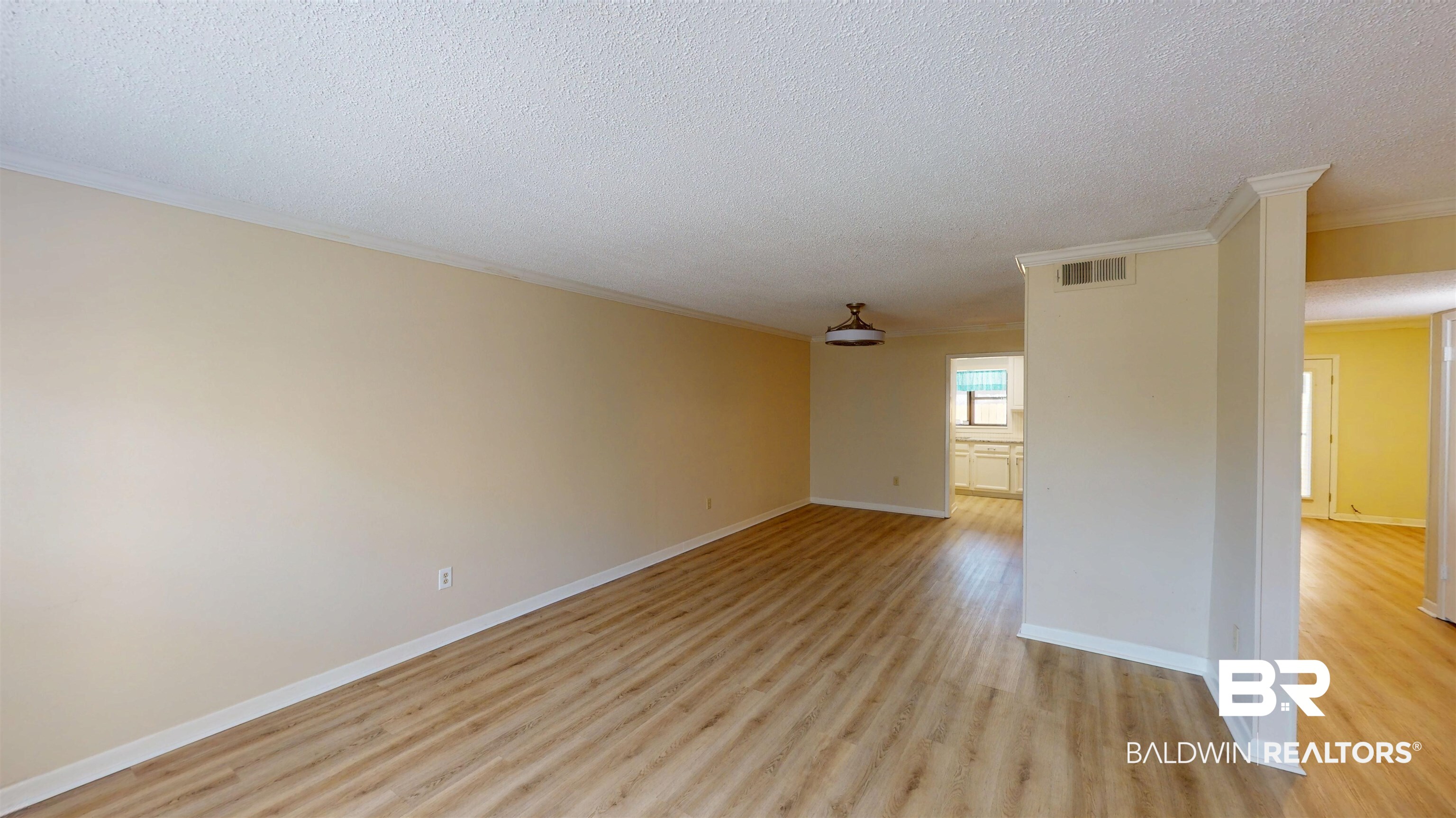 2901 Grant Street, Unit 902 Mobile, AL 36606 - Photo 2 of 35 Empty room with light wood-style floors, crown molding, and a textured ceiling