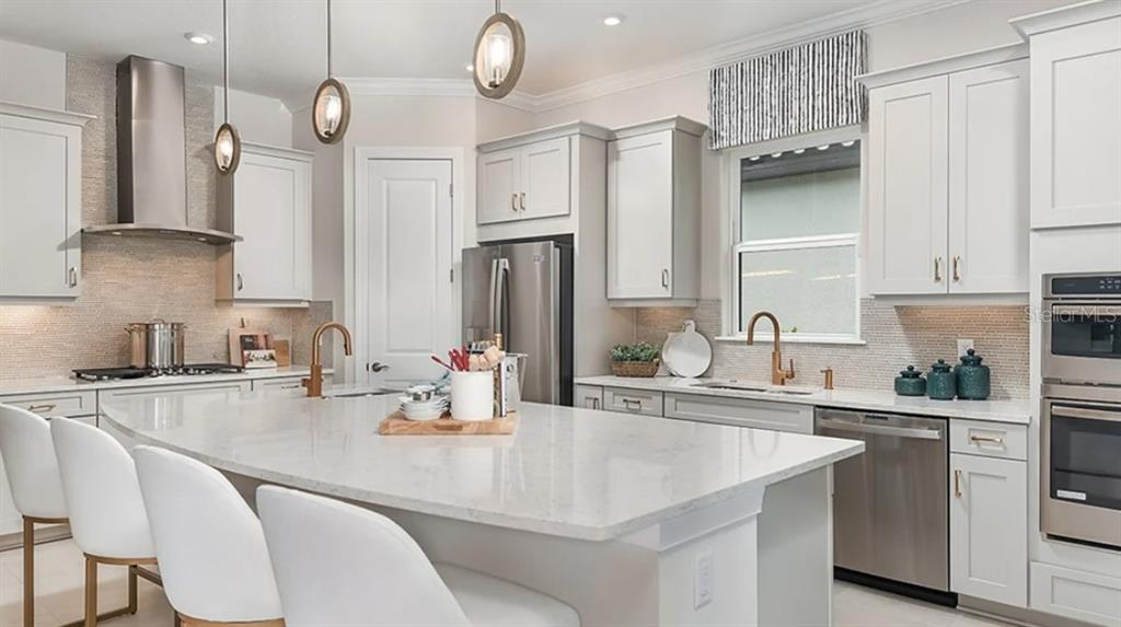 14923 Contenta Loop Bradenton, FL 34211 - Photo 3 of 31 a kitchen with a sink dishwasher a stove a refrigerator and cabinets with wooden floor
