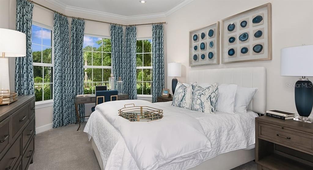 14923 Contenta Loop Bradenton, FL 34211 - Photo 5 of 31 a bedroom with a large bed and a flat tv screen on dresser