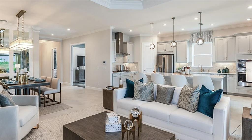 14923 Contenta Loop Bradenton, FL 34211 - Photo 10 of 31 a living room with furniture kitchen area and a chandelier