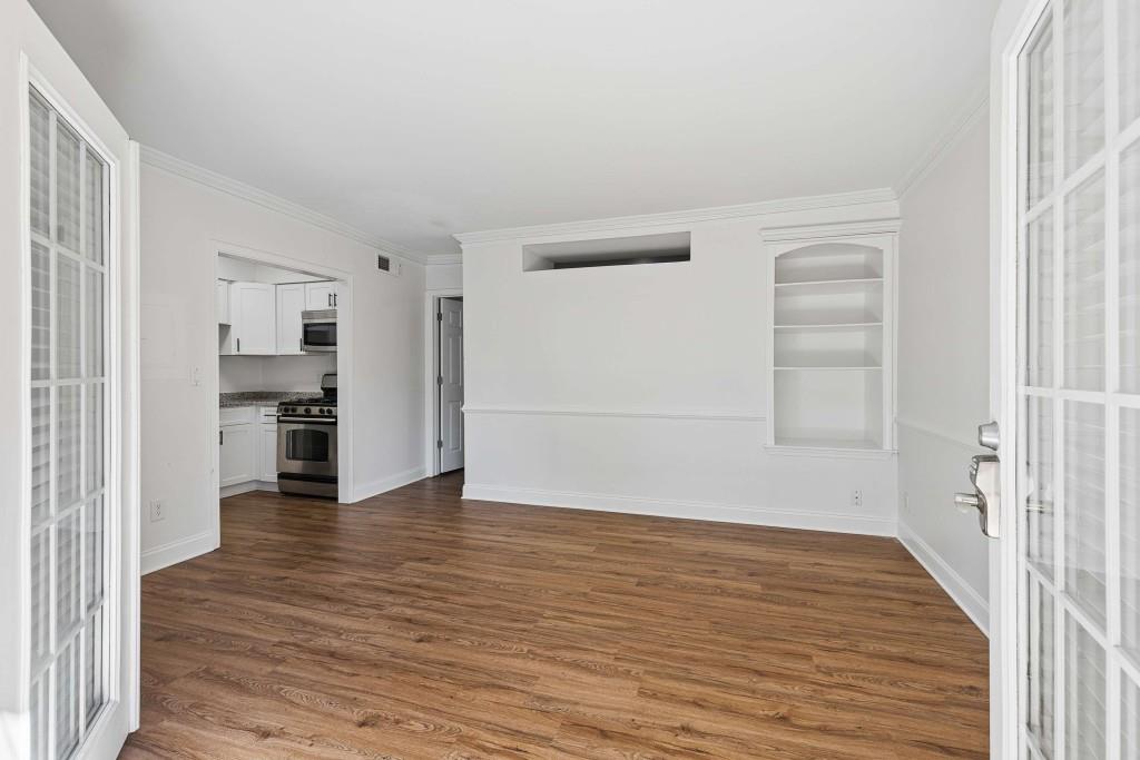 6980 Roswell Road, Unit C13 Atlanta, GA 30328 - Photo 16 of 49 a view of a hallway with wooden floor and a kitchen