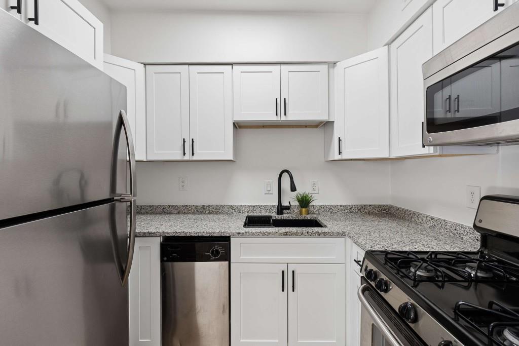6980 Roswell Road, Unit C13 Atlanta, GA 30328 - Photo 17 of 49 a kitchen with stainless steel appliances granite countertop a sink stove and microwave