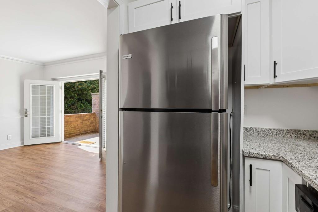 6980 Roswell Road, Unit C13 Atlanta, GA 30328 - Photo 22 of 49 a view of a refrigerator in kitchen and an empty room with wooden floor