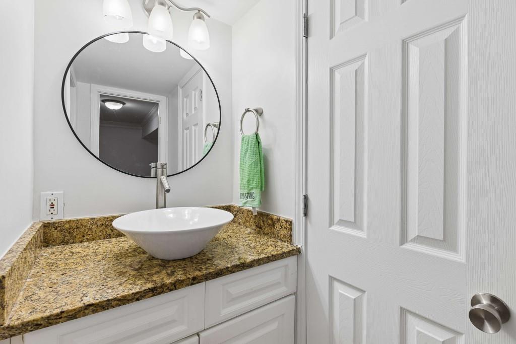 6980 Roswell Road, Unit C13 Atlanta, GA 30328 - Photo 35 of 49 a bathroom with a granite countertop sink and a mirror