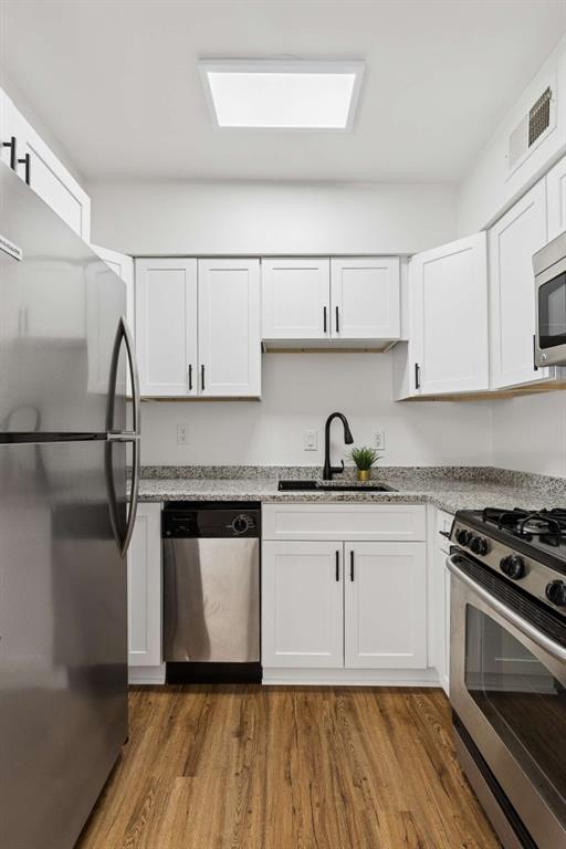 6980 Roswell Road, Unit C13 Atlanta, GA 30328 - Photo 37 of 49 a kitchen with granite countertop a stove and white cabinets