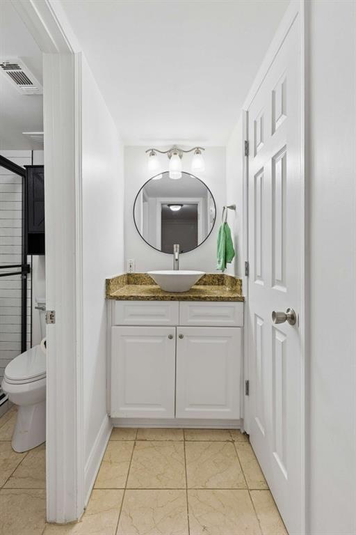 6980 Roswell Road, Unit C13 Atlanta, GA 30328 - Photo 41 of 49 a bathroom with a granite countertop sink a toilet and a mirror