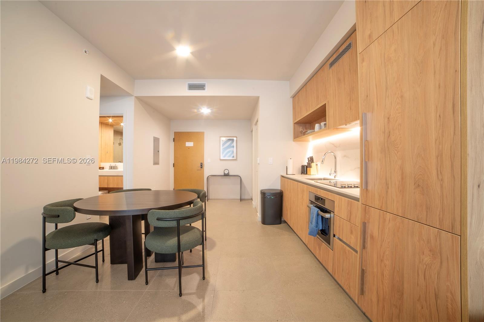 11 Northeast 6th Street, Unit 1403 Miami, FL 33132 - Photo 1 of 44 a kitchen with a table chairs sink and cabinets