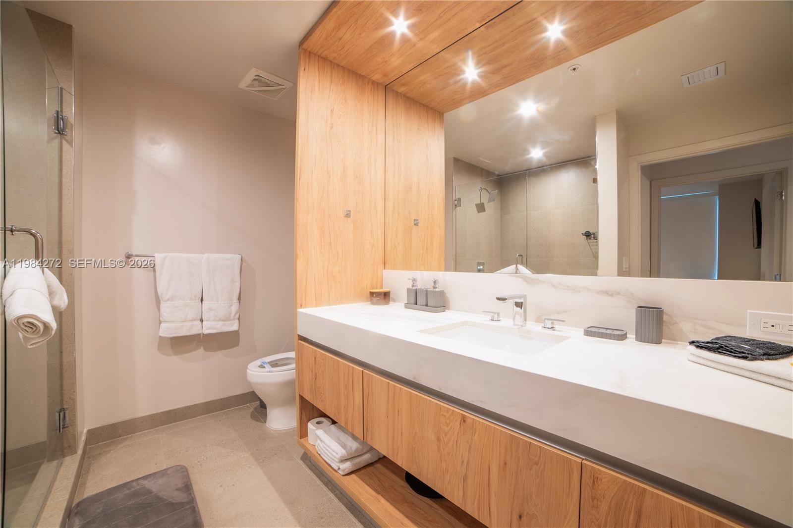 11 Northeast 6th Street, Unit 1403 Miami, FL 33132 - Photo 14 of 44 a spacious bathroom with a double vanity sink toilet and a mirror