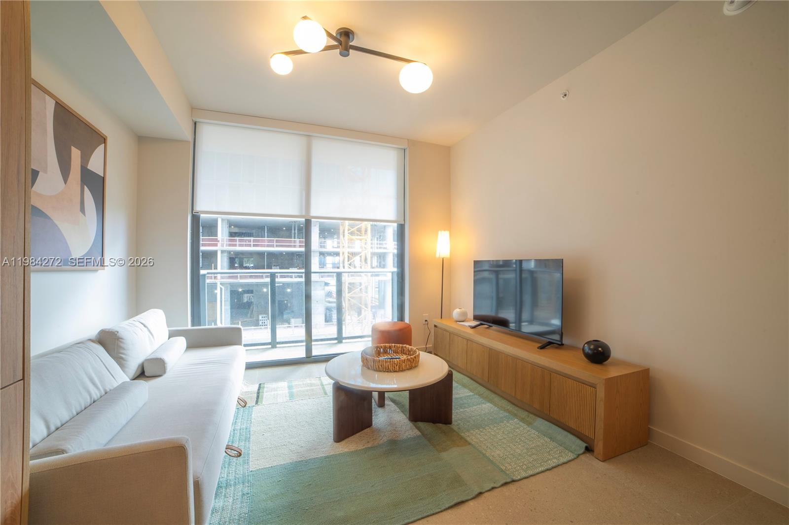 11 Northeast 6th Street, Unit 1403 Miami, FL 33132 - Photo 7 of 44 a living room with furniture and a flat screen tv