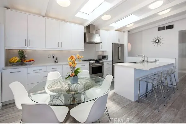 a dining room with furniture a chandelier and kitchen view