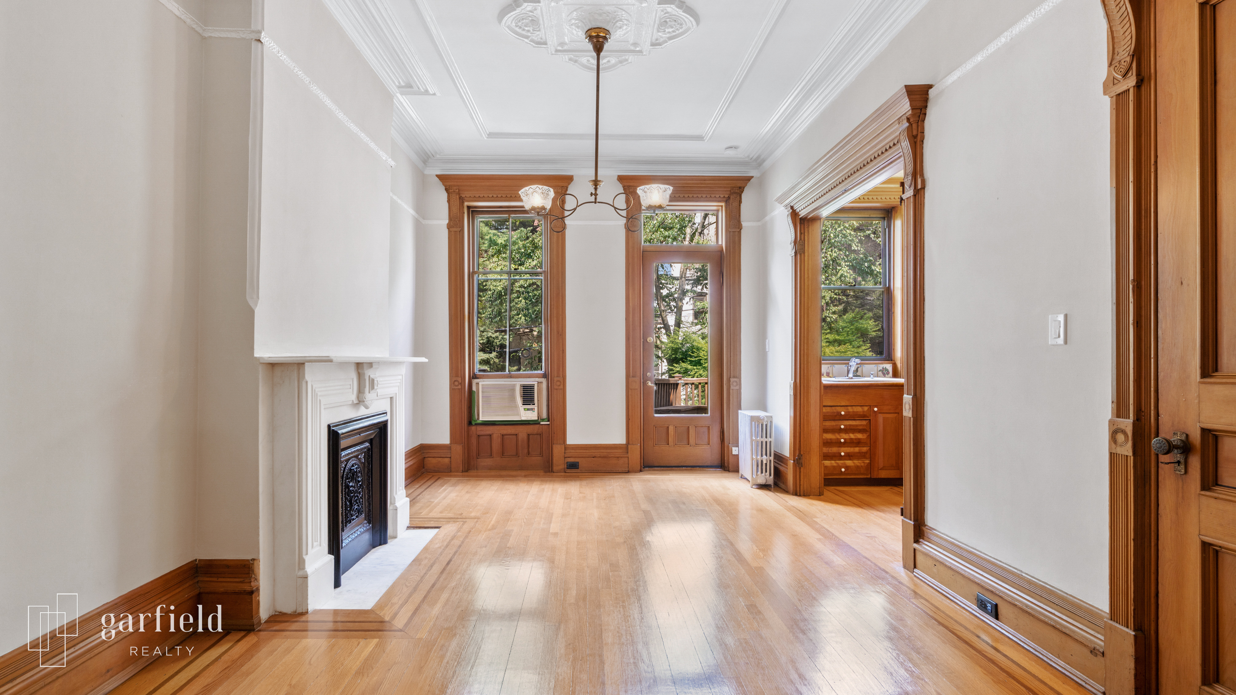 a view of an empty room with a fireplace and a window