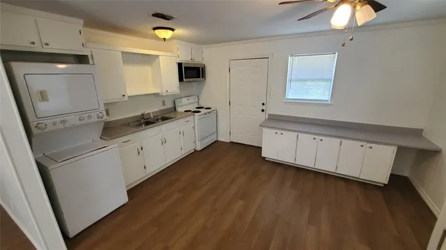 a open kitchen with white cabinets and stainless steel appliances
