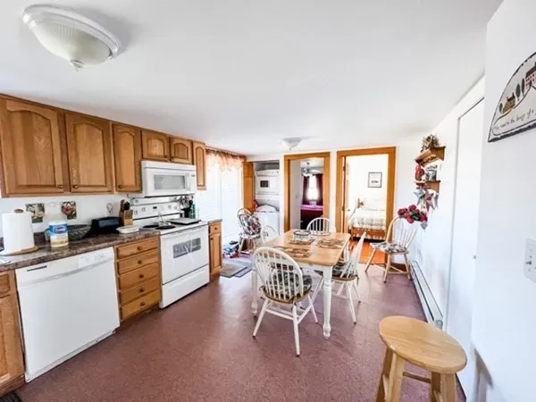 a kitchen with a table chairs refrigerator and cabinets