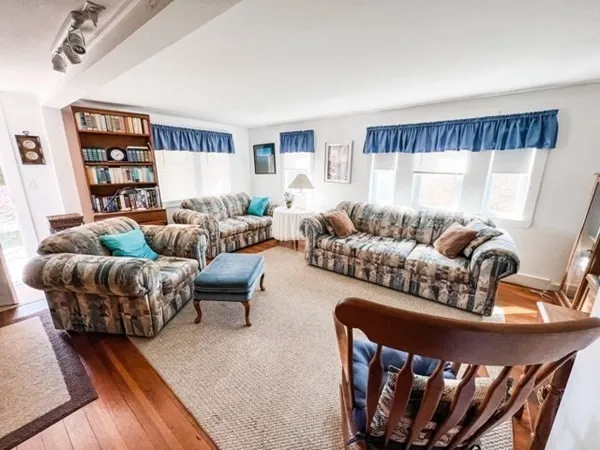 a living room with furniture a rug and a window