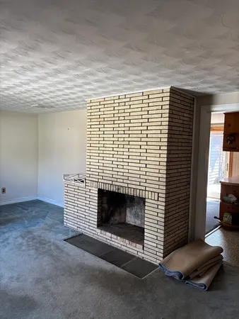 a view of empty room with fireplace and window