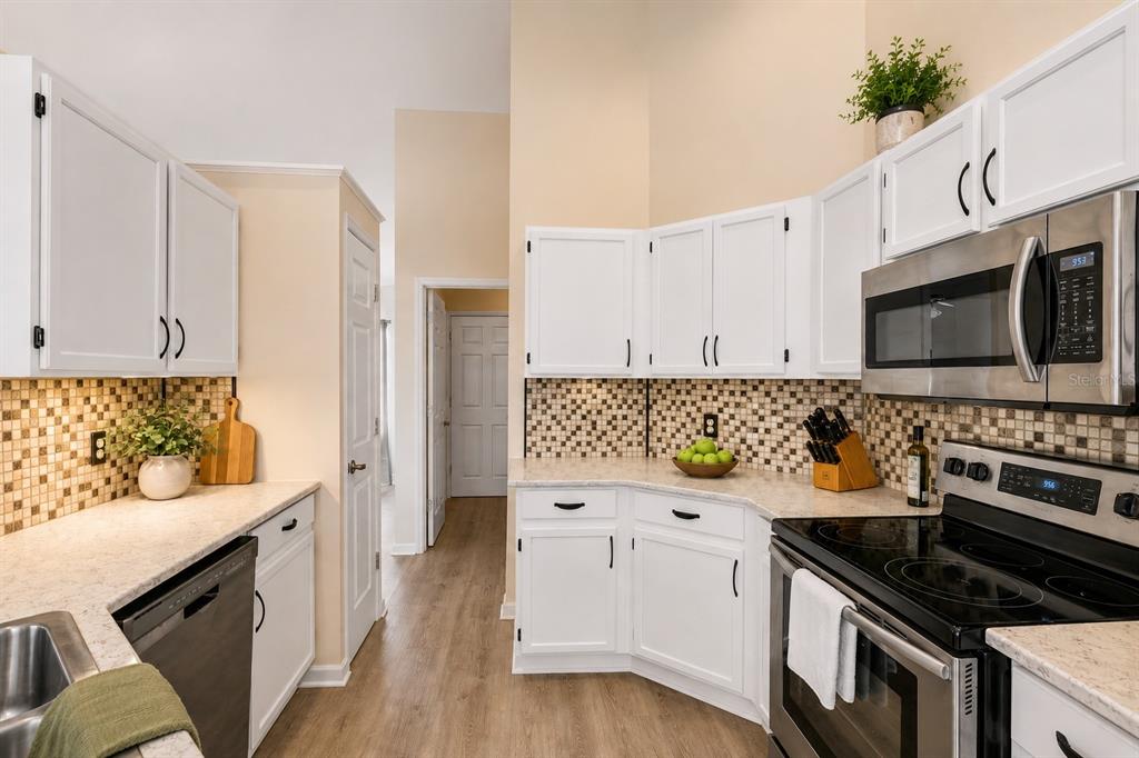 12232 Bronson Way Orlando, FL 32824 - Photo 3 of 32 a kitchen with stainless steel appliances a stove a sink and a microwave