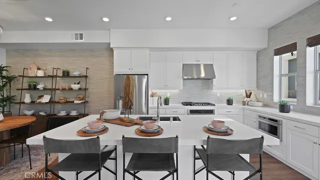 a kitchen with a dining table cabinets and chairs