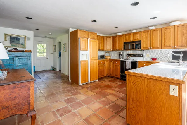 a kitchen with stainless steel appliances granite countertop a refrigerator a stove top oven a sink dishwasher and wooden cabinets