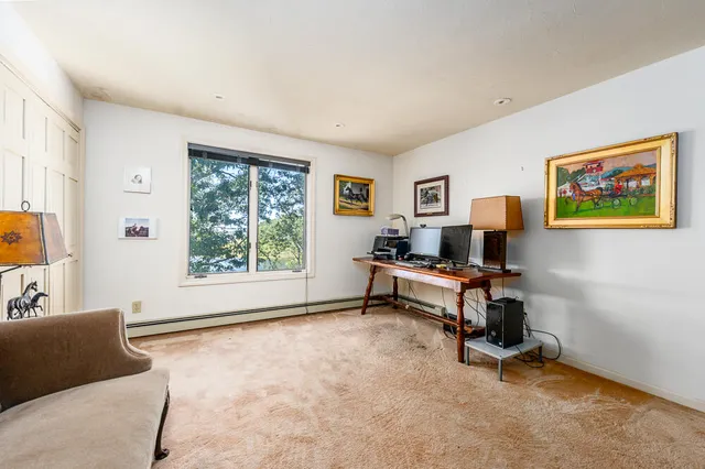 a view of a livingroom with workspace and a window
