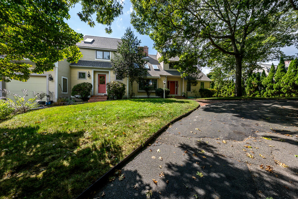 498 Elliott Road Centerville, MA 02632 - Photo 4 of 32 a view of a white house with a yard plants and large tree