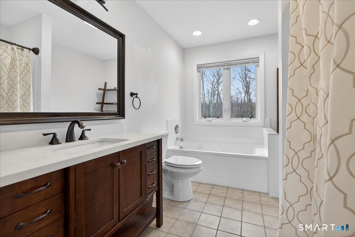 22 Emerald Lane Bethany, CT 06524 - Photo 19 of 28 a bathroom with a double vanity sink toilet mirror and bathtub