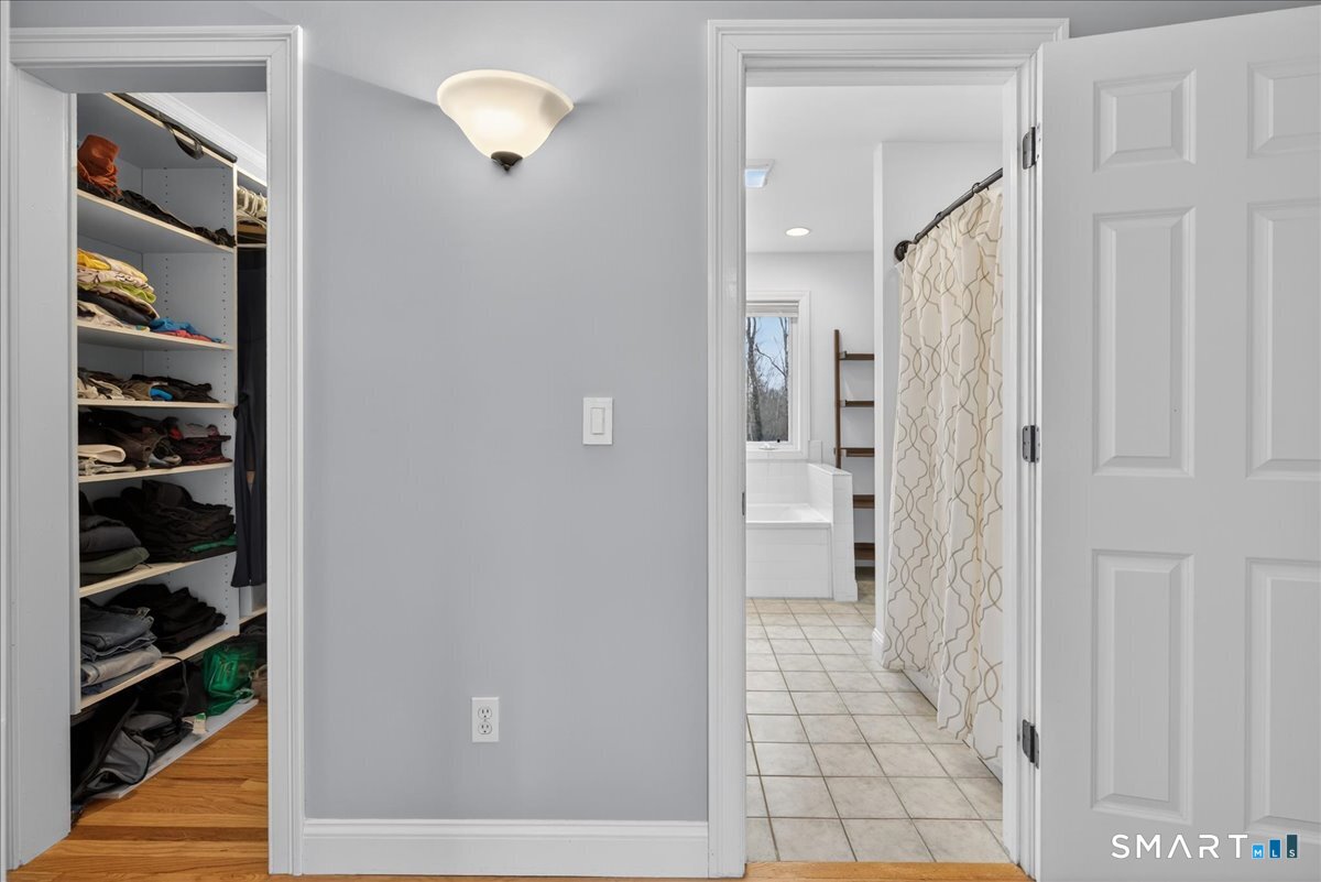 22 Emerald Lane Bethany, CT 06524 - Photo 20 of 28 a view of a hallway with wooden floor and cabinet