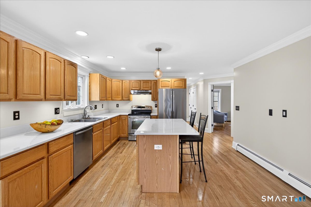 22 Emerald Lane Bethany, CT 06524 - Photo 8 of 28 a large kitchen with a center island wooden floor and stainless steel appliances