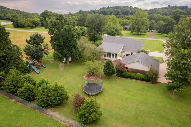 an aerial view of a house with a garden and lake view