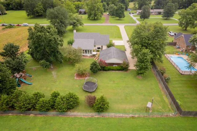 an aerial view of a house with a yard basket ball court and outdoor seating